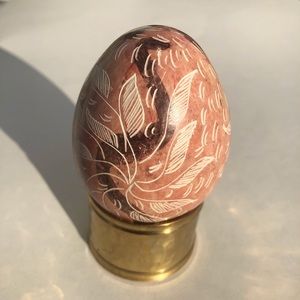 Pink stone engraved egg with snakes